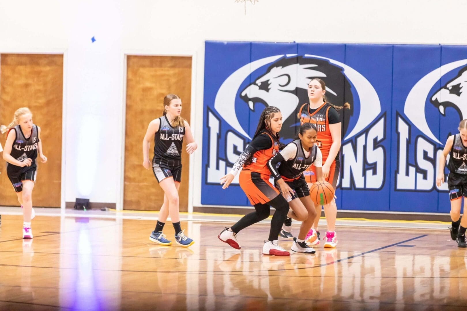 Girls playing basketball in a school gym