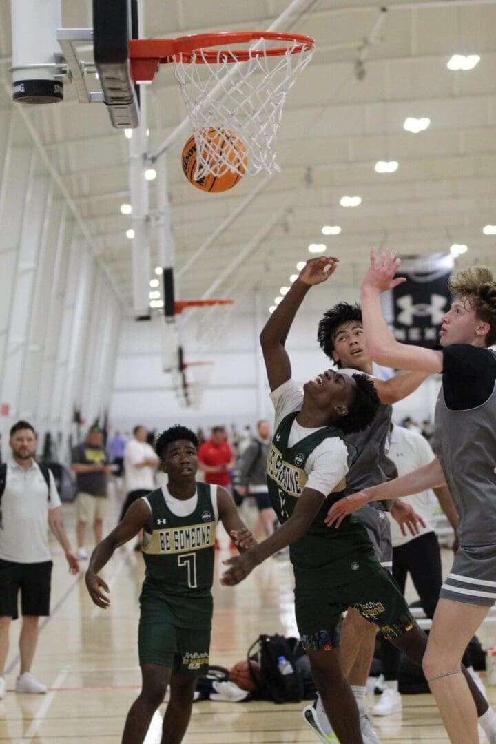 Basketball players reaching for the ball.