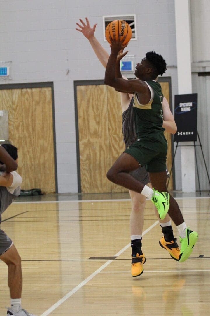 Basketball player jumping to shoot ball.