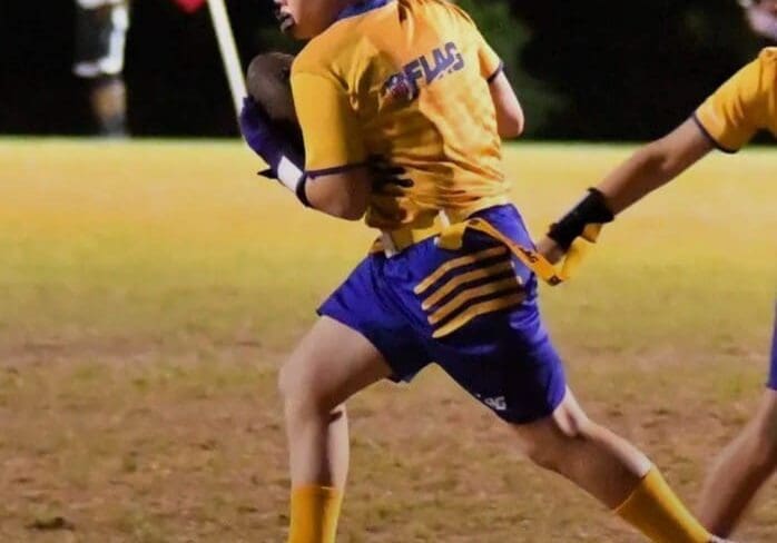 Youth flag football player running with ball.