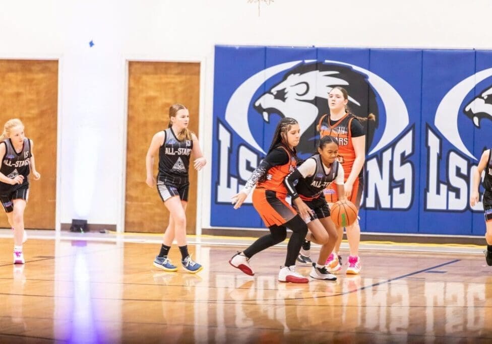 Girls' basketball game in action on court.